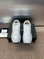 Chanel unisex white sneakers, front view pair on display boxes