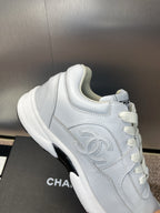 Chanel unisex white sneakers, close-up of side panel and lace-up