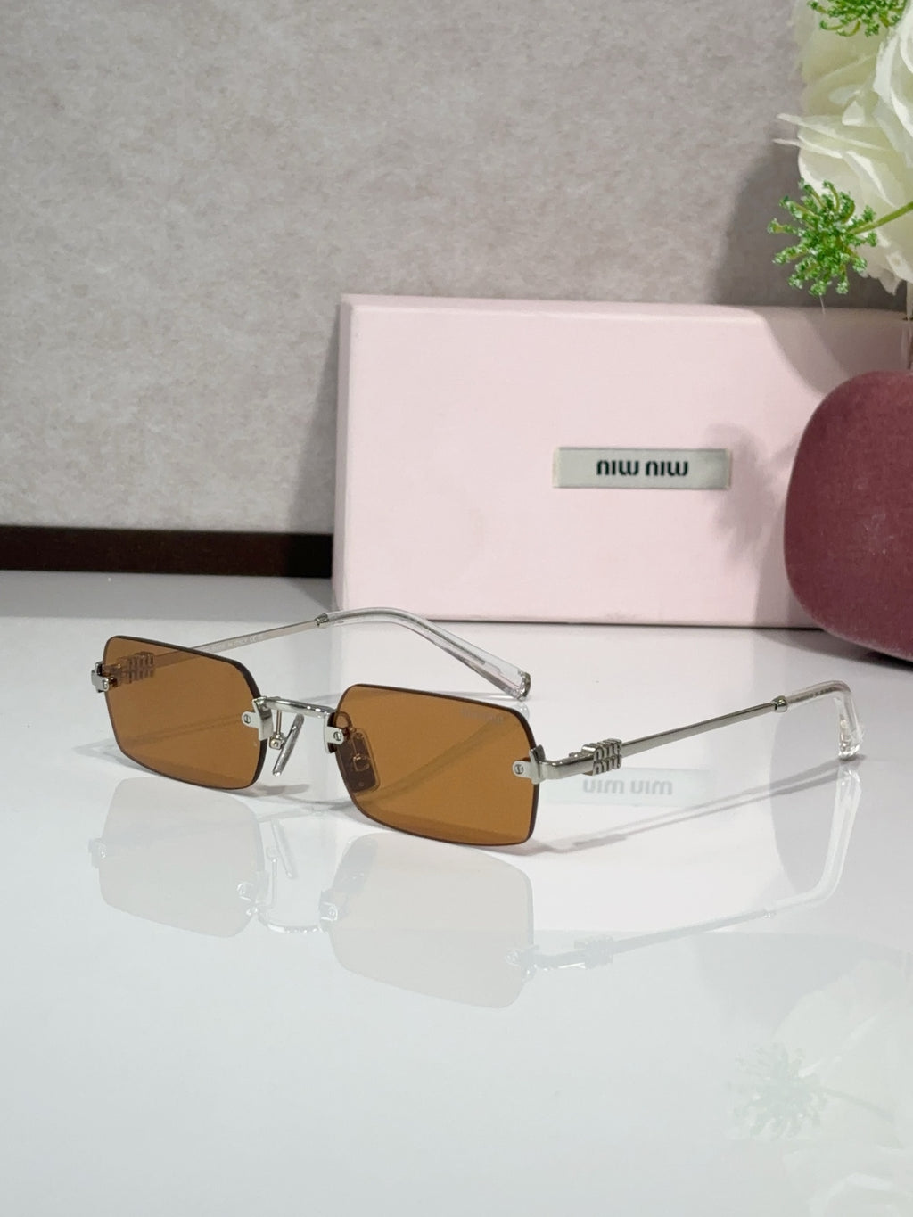 MiuMiu glasses with gold frame and brown tinted lenses, clear temple arms