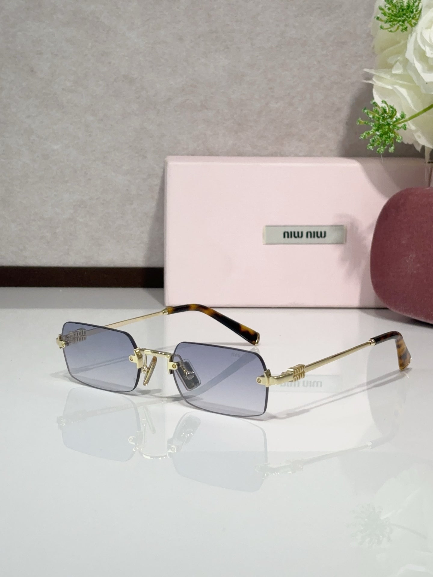 MiuMiu glasses with gold frame, blue tinted lenses, tortoise temple tips