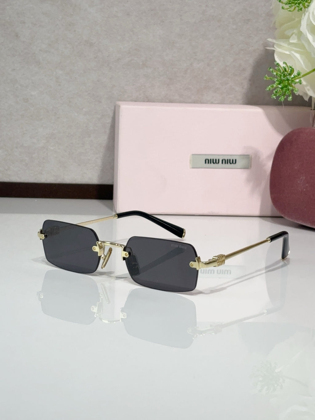 MiuMiu glasses with gold frame and dark lenses, black temple arms