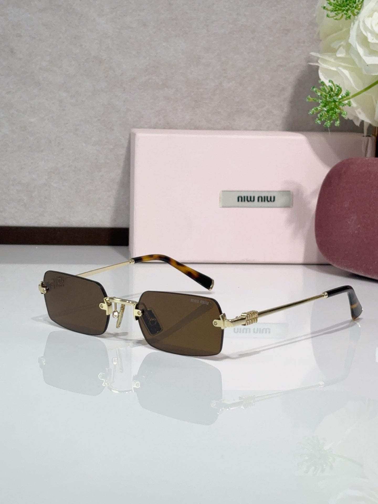 MiuMiu glasses with gold frame, dark brown tinted lenses, muted temple arms