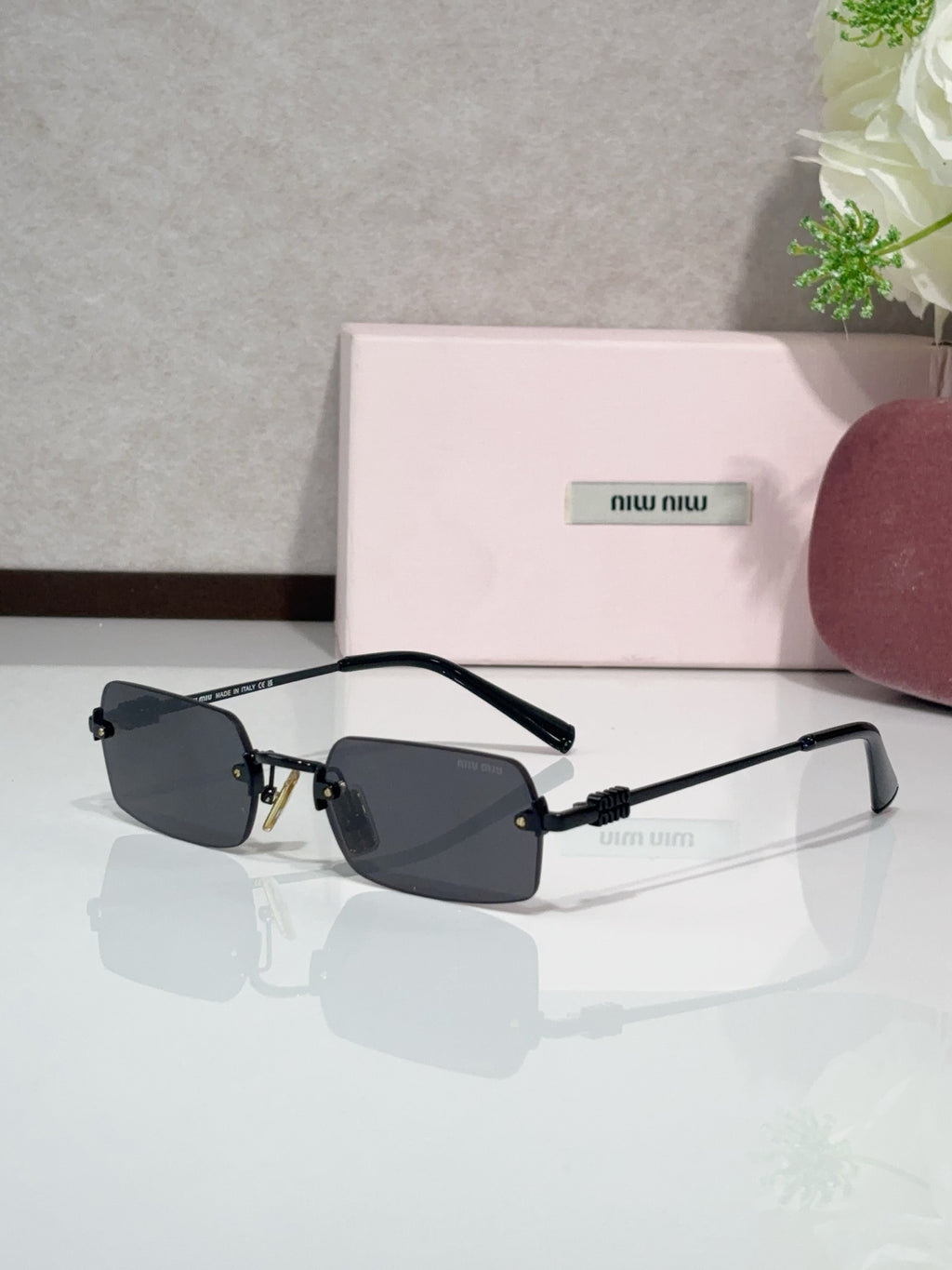 MiuMiu glasses with gold frame and dark blue tinted lenses, black temple arms