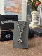Silver-tone charm necklace on black display card, featuring square pendant and chain