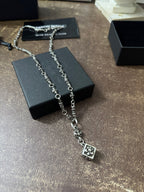 Silver-tone charm necklace with square pendant, shown on black jewelry box