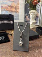 Silver-tone charm necklace on display card with square pendant charm and short beaded chain.