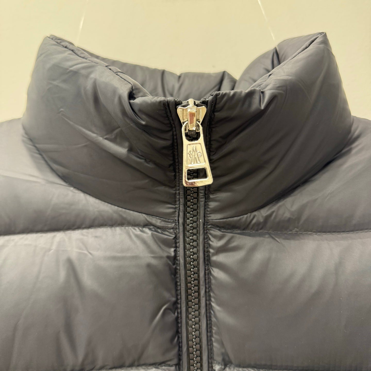 Puffer jacket collar with gold-tone zip pull and quilted padding, dark gray