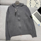 Gray cable-knit zip hoodie with hood, ribbed cuffs and hem on couch