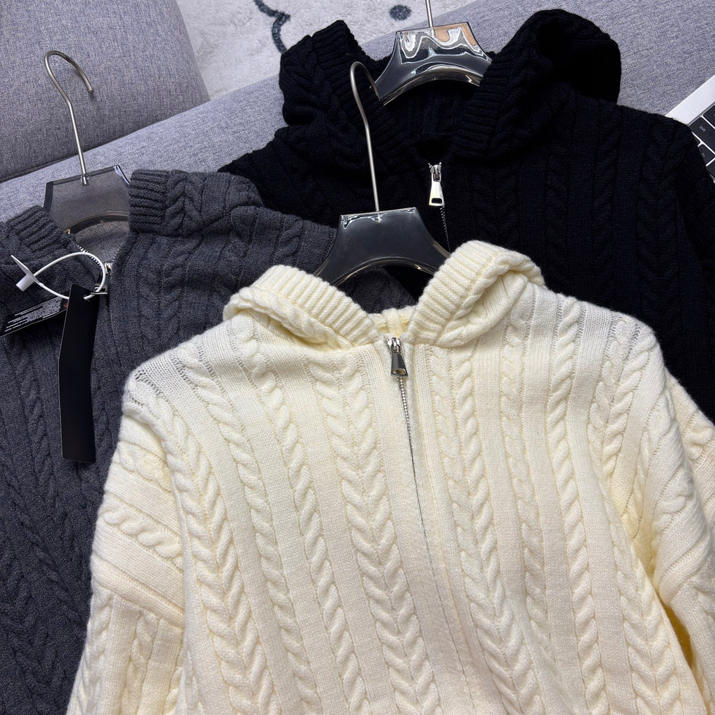 Cream cable-knit zip hoodie with hood and zipper, close-up on hanger