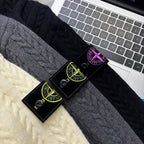 Cable-knit fabric swatches in dark gray and cream with product tags