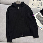 Black cable-knit zip hoodie with hood, ribbed cuffs and hem on couch