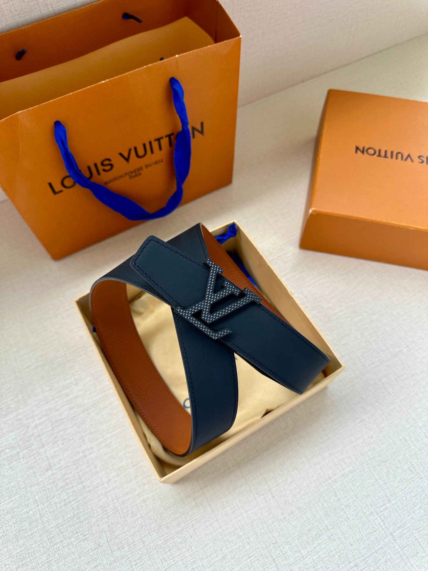 Louis Vuitton tan leather belt with gold-tone LV buckle and textured strap