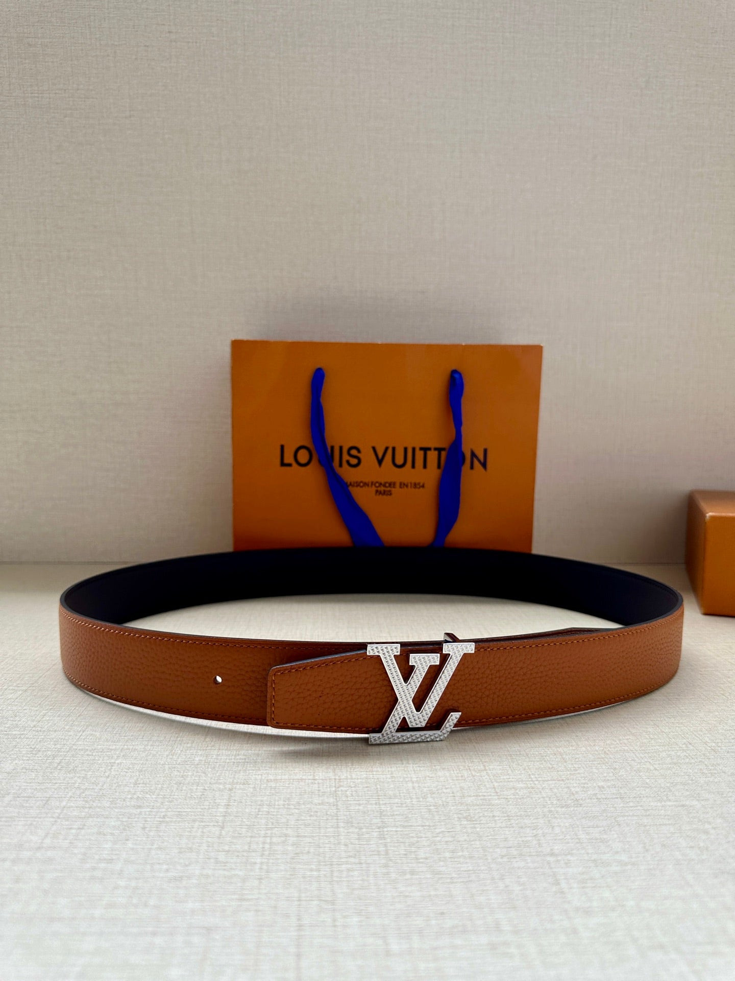 Louis Vuitton leather belt with LV silver buckle, tan strap and dark inner lining