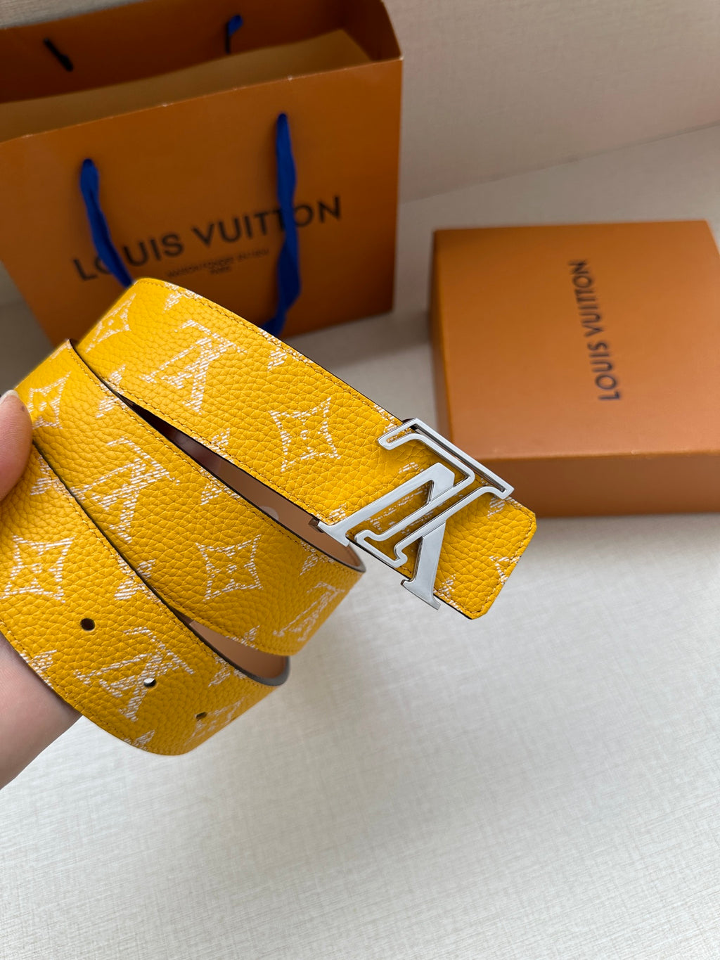 Yellow monogram belt close-up with silver-toned buckle hardware