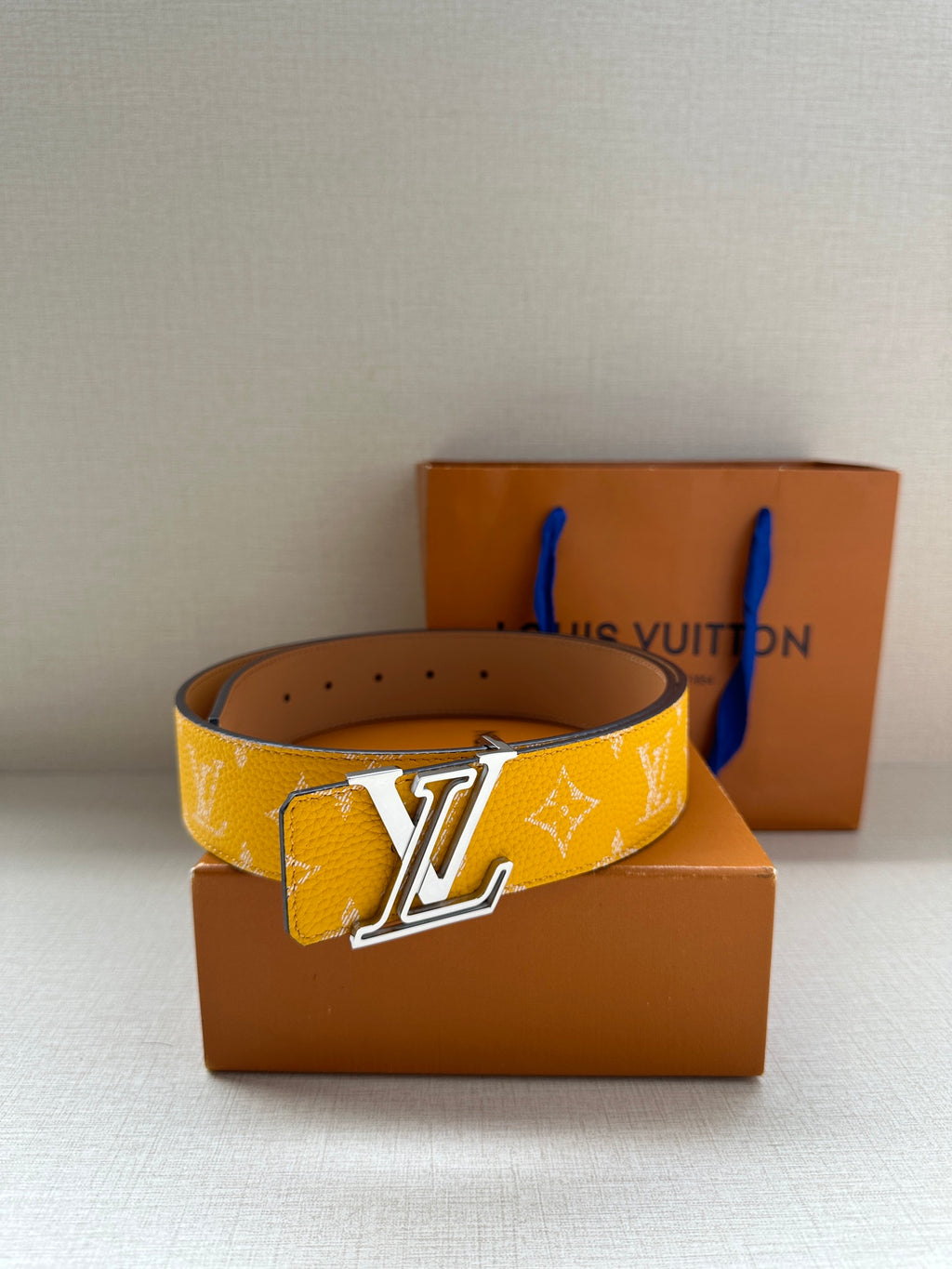 Yellow monogram belt with gold-tone LV buckle, flat front view