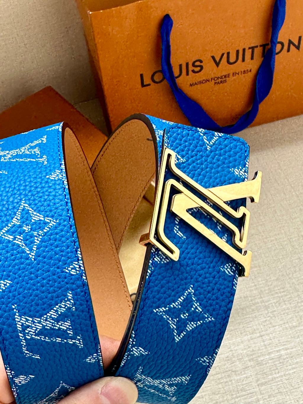 Blue monogram belt with gold and silver LV buckle and tan leather strap