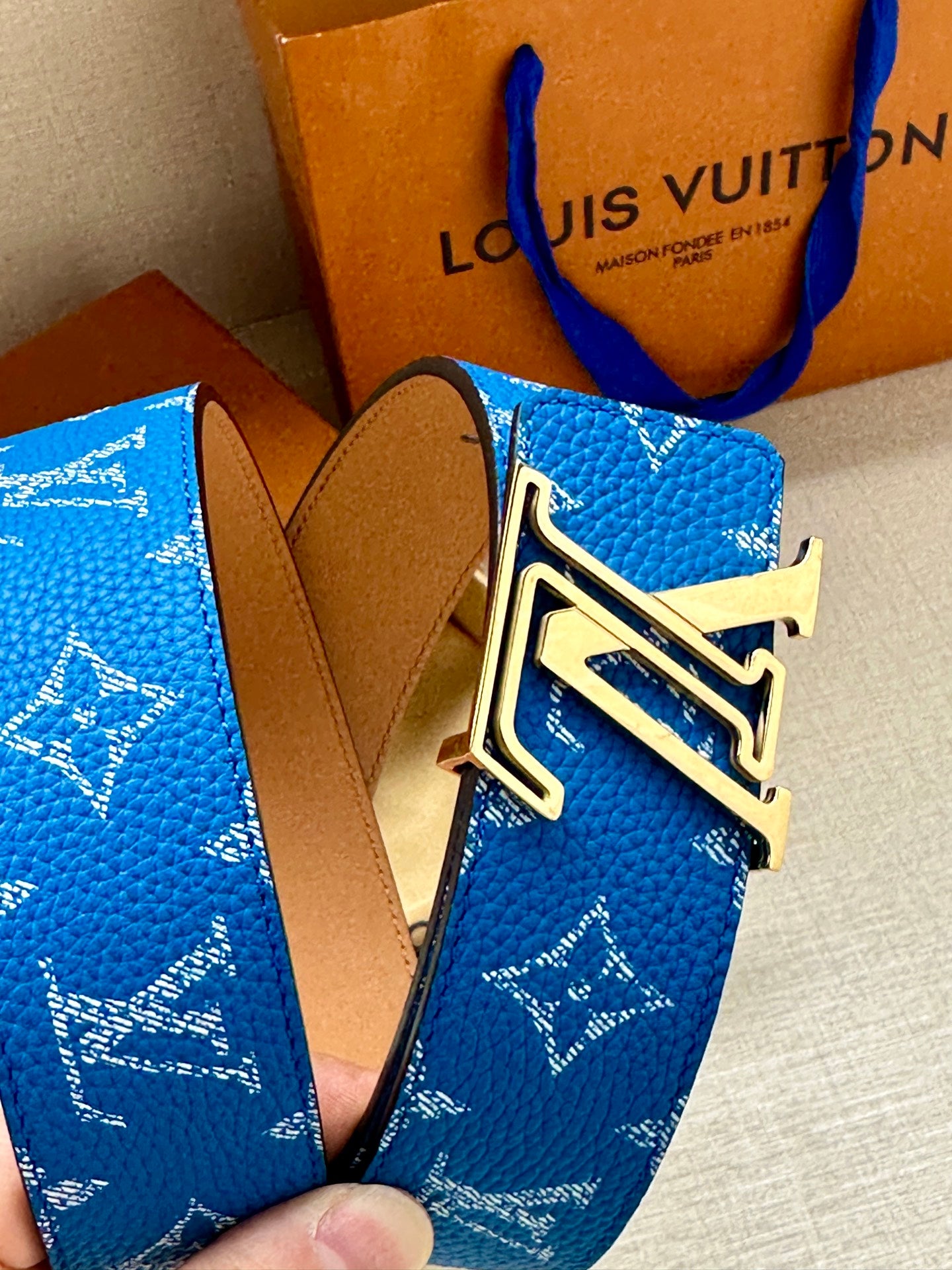 Blue monogram belt with gold and silver LV buckle and tan leather strap
