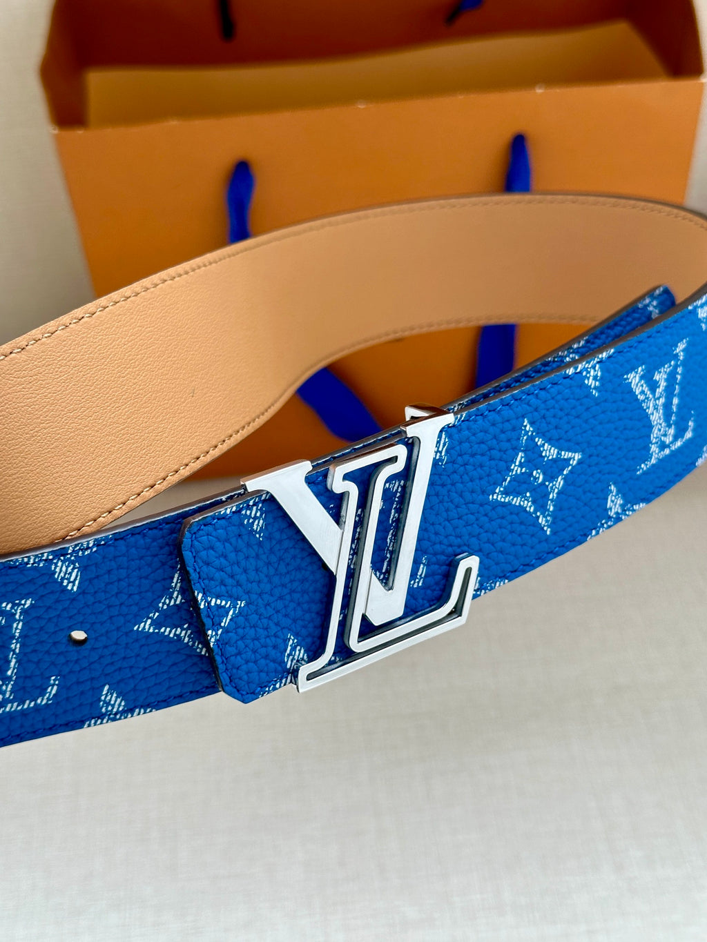 Blue monogram Louis Vuitton belt with silver LV buckle and tan leather backing