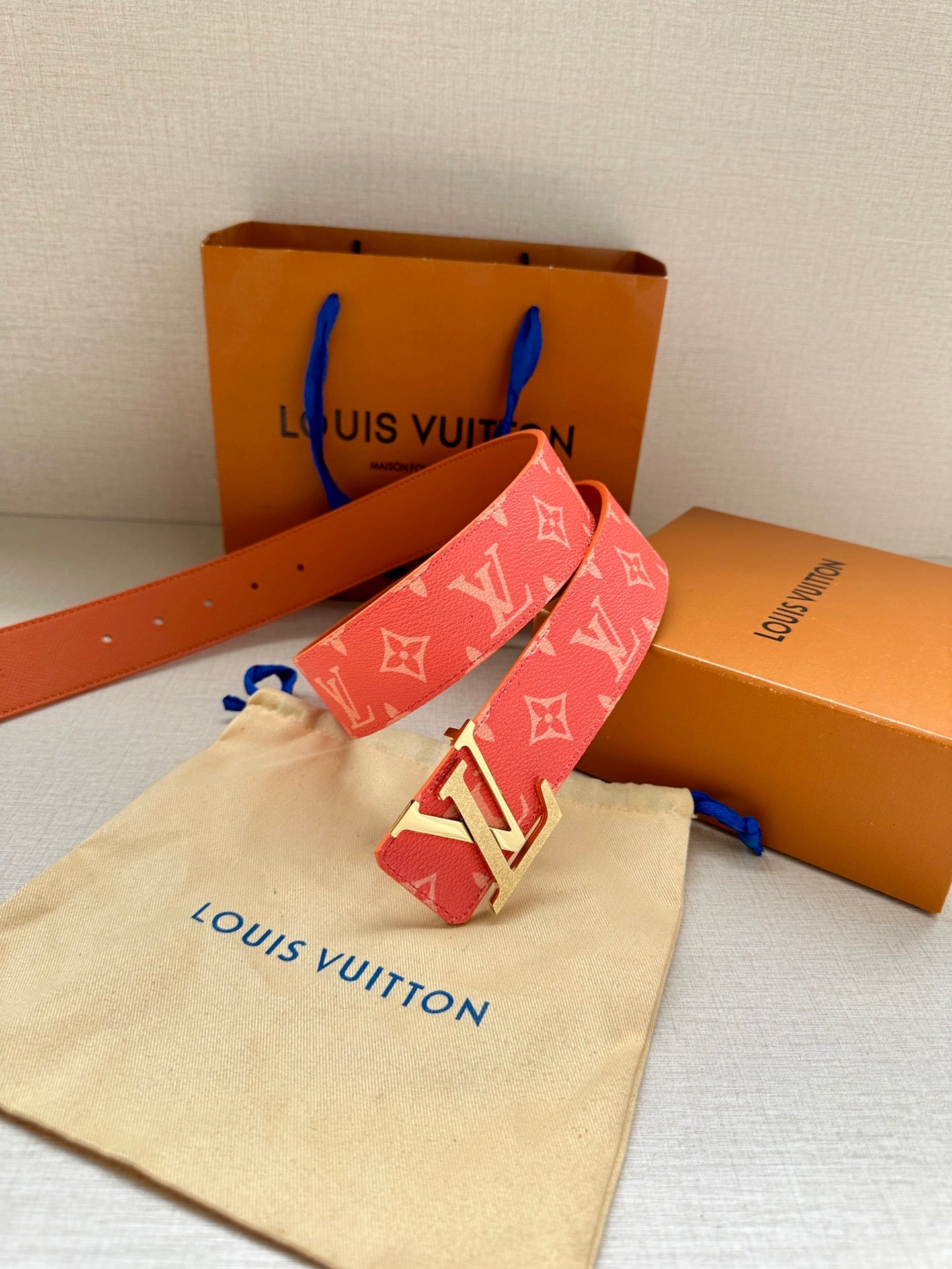 Louis Vuitton belt in red monogram canvas with gold-tone LV buckle and tan reverse side