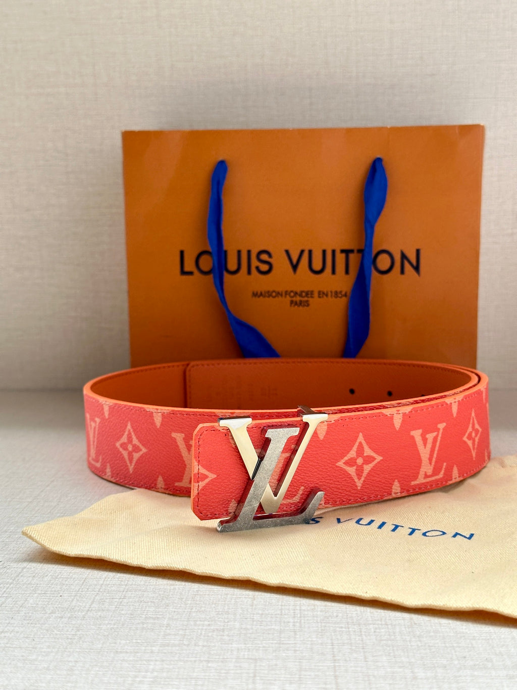 Louis Vuitton belt front view: red monogram strap with gold-tone LV buckle