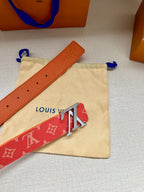 Louis Vuitton belt close-up: red monogram strap with gold-tone LV buckle and hole details