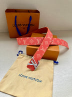 Louis Vuitton belt featuring red monogram canvas strap and gold-tone LV buckle