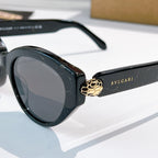 Bvlgari cat-eye sunglasses close-up, black frames, gray lenses, gold emblem