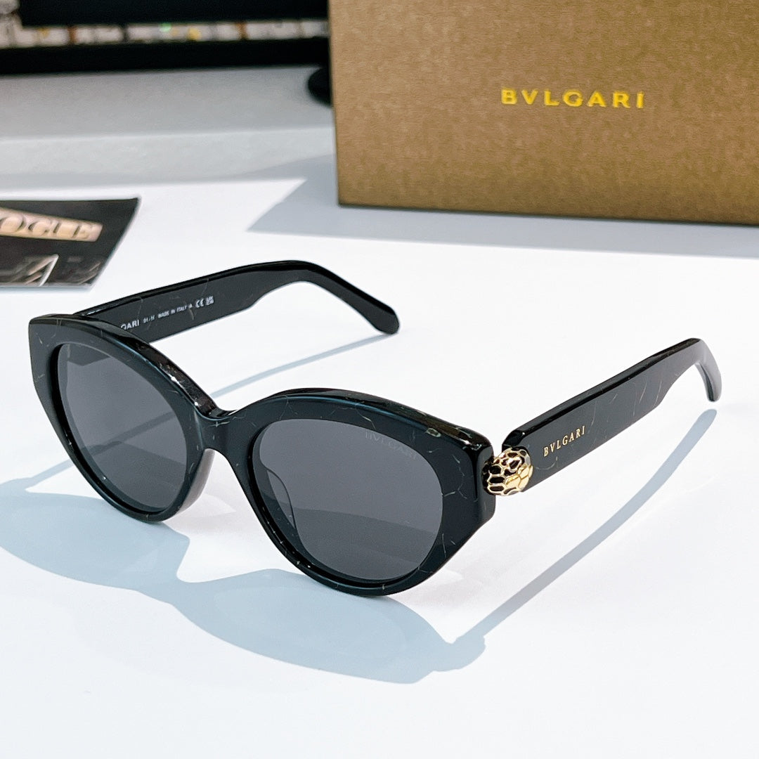 Bvlgari cat-eye sunglasses, dark frames, gray-tinted lenses, gold emblem bridge