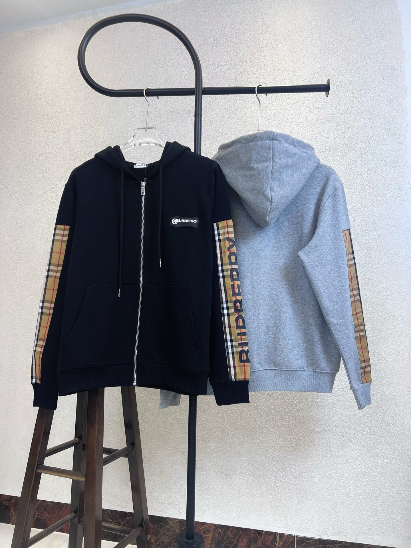 Zip-up hoodies: navy front and light gray back view, plaid sleeve panels.