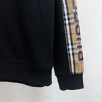 Black hoodie sleeve cuff with plaid side panel and vertical Burberry lettering