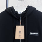 Black zip-up hoodie with hood, metal zipper, and Burberry logo label