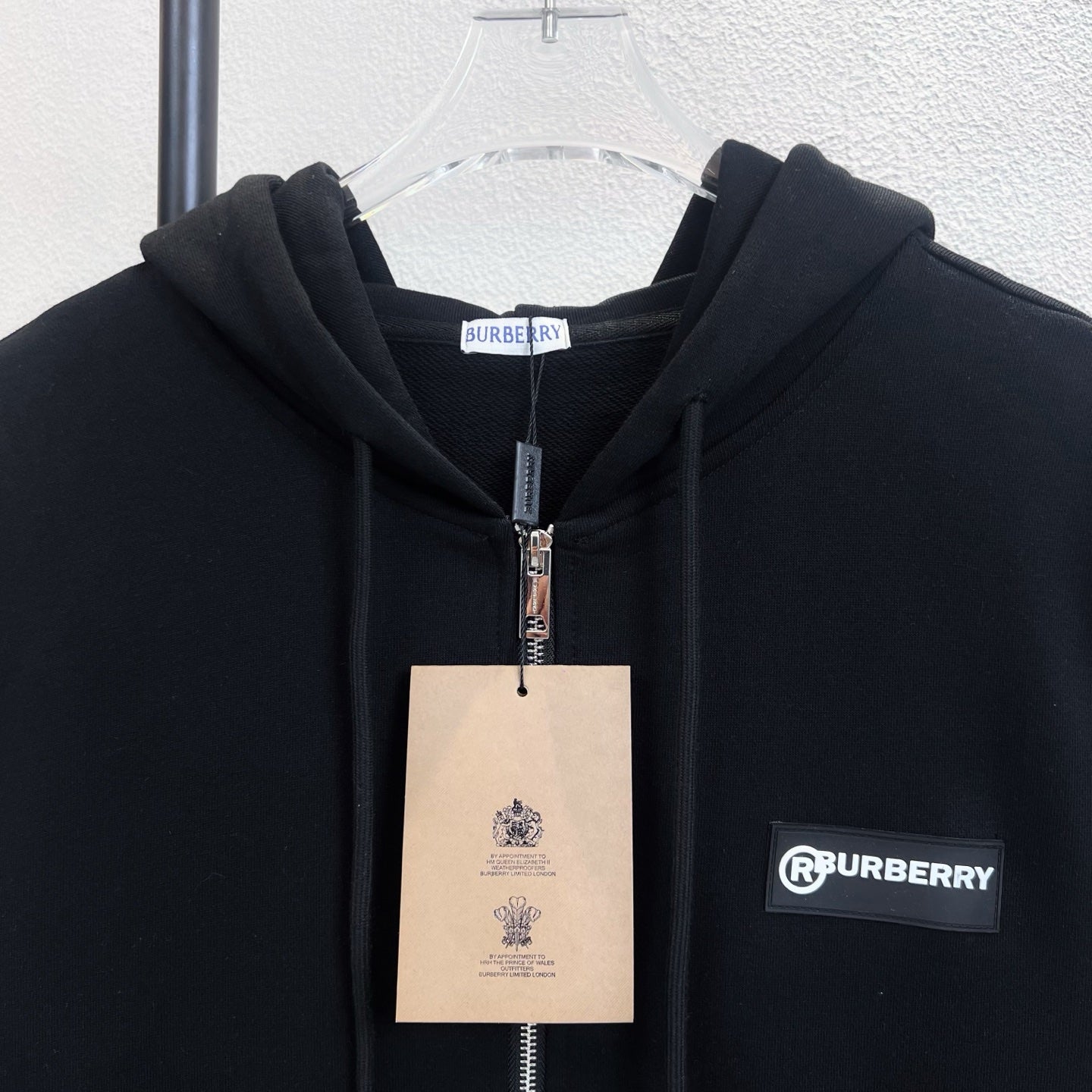 Black zip-up hoodie with hood, metal zipper, and Burberry logo label