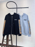 Zip-up hoodies on hangers: navy and light gray with plaid sleeve panels.