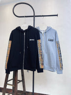 Zip-up hoodies on hangers: navy and light gray with plaid sleeve panels.
