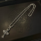 Silver-tone chain necklace close-up with cross star pendant and bead link pattern