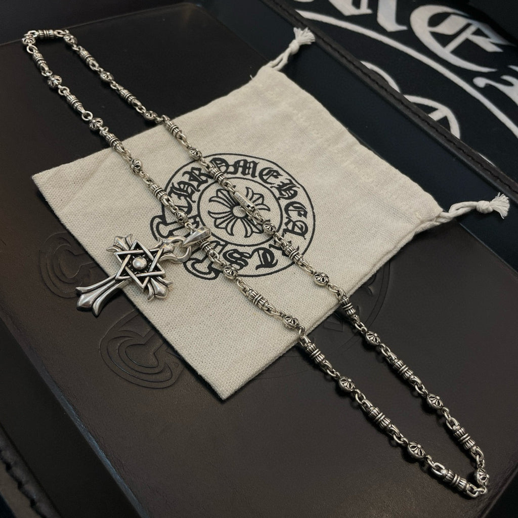 Silver-tone chain necklace with cross star pendant and circular emblem charm