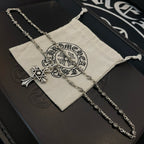 Silver-tone chain necklace with cross star pendant and circular emblem charm