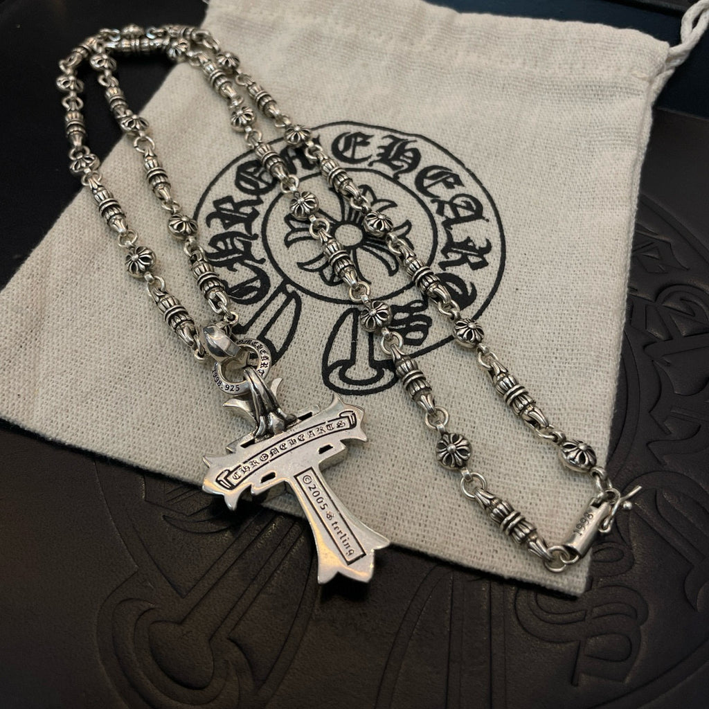 Silver-tone chain necklace with cross pendant and engraved tag detail
