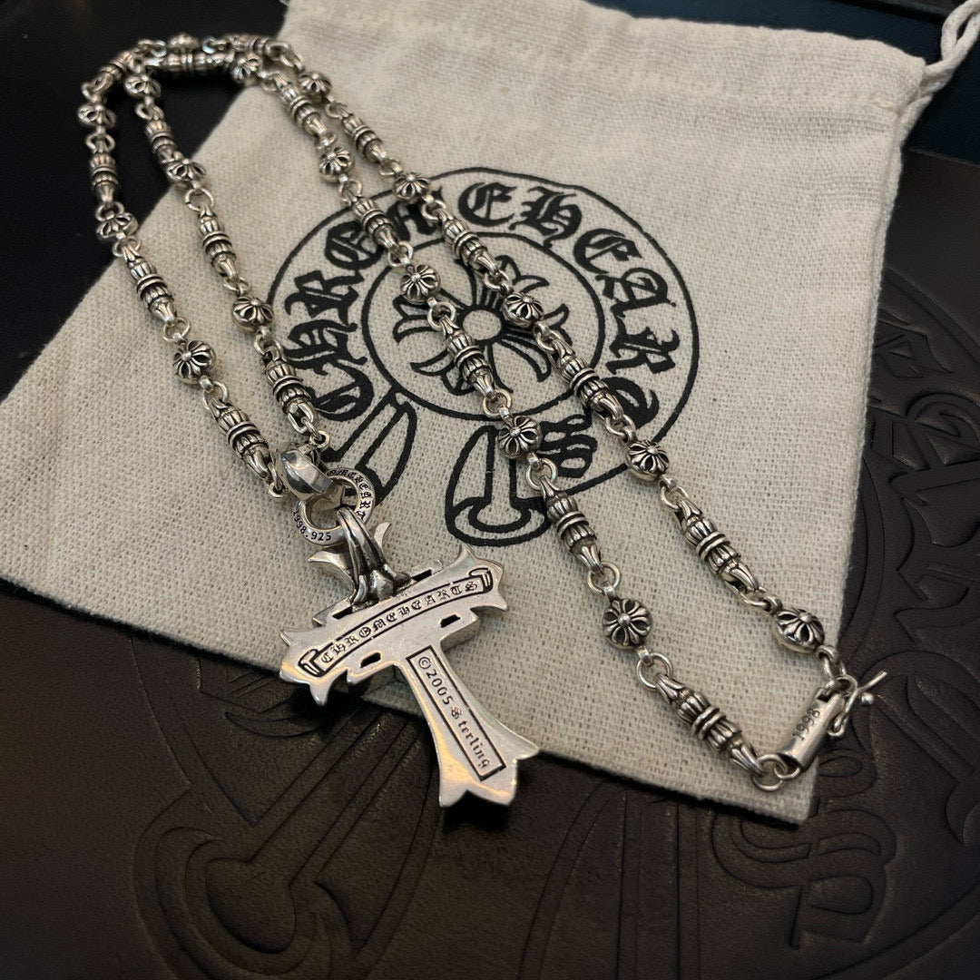 Silver-tone chain necklace with cross pendant and engraved tag detail