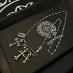 Silver-tone pendant necklace with cross and small charm details on a chain