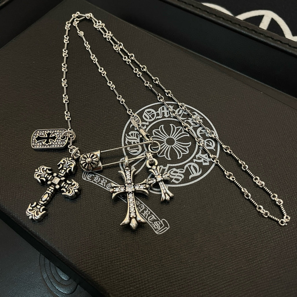 Gold-tone cross pendant necklace with chain links and flower-style charm accents