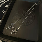Silver-tone cross pendant necklace with hanging charms and chain links