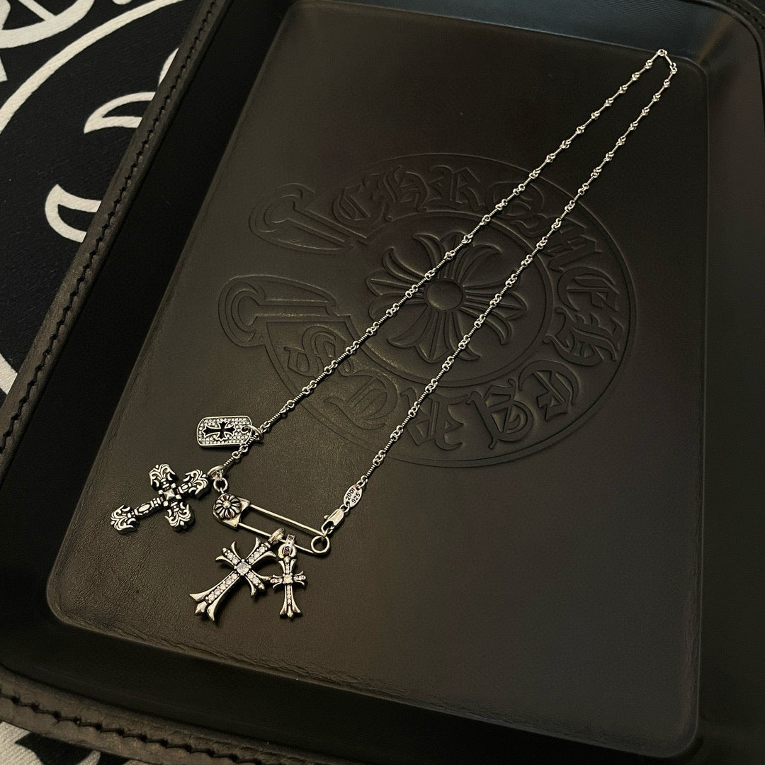 Silver-tone cross pendant necklace with hanging charms and chain links