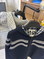 Dior hooded zip jacket close-up: dark navy body, striped sleeves, patterned hood lining