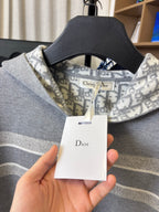 Gray Dior logo hoodie neckline close-up with hanging product tag