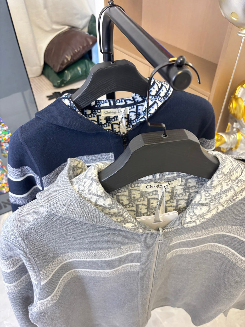 Navy zip-up hoodie with light logo trim on hood and sleeves