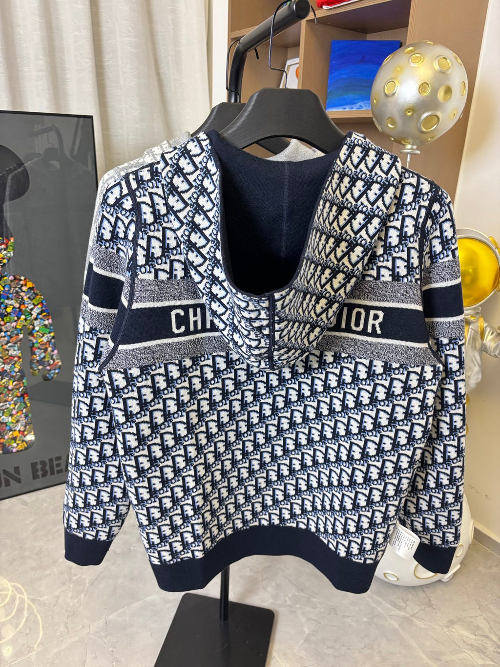 Dior hooded zip jacket front view with navy collar, patterned body and chest logo stripe