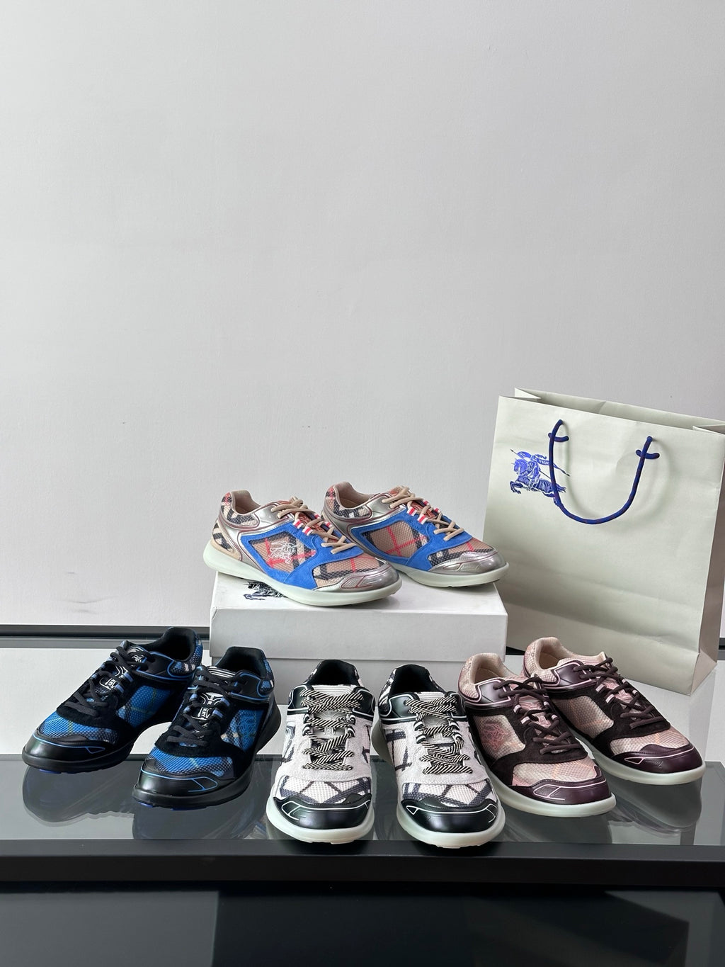 Multiple sneakers on display: blue, black, pink, and multicolor pairs on shoeboxes