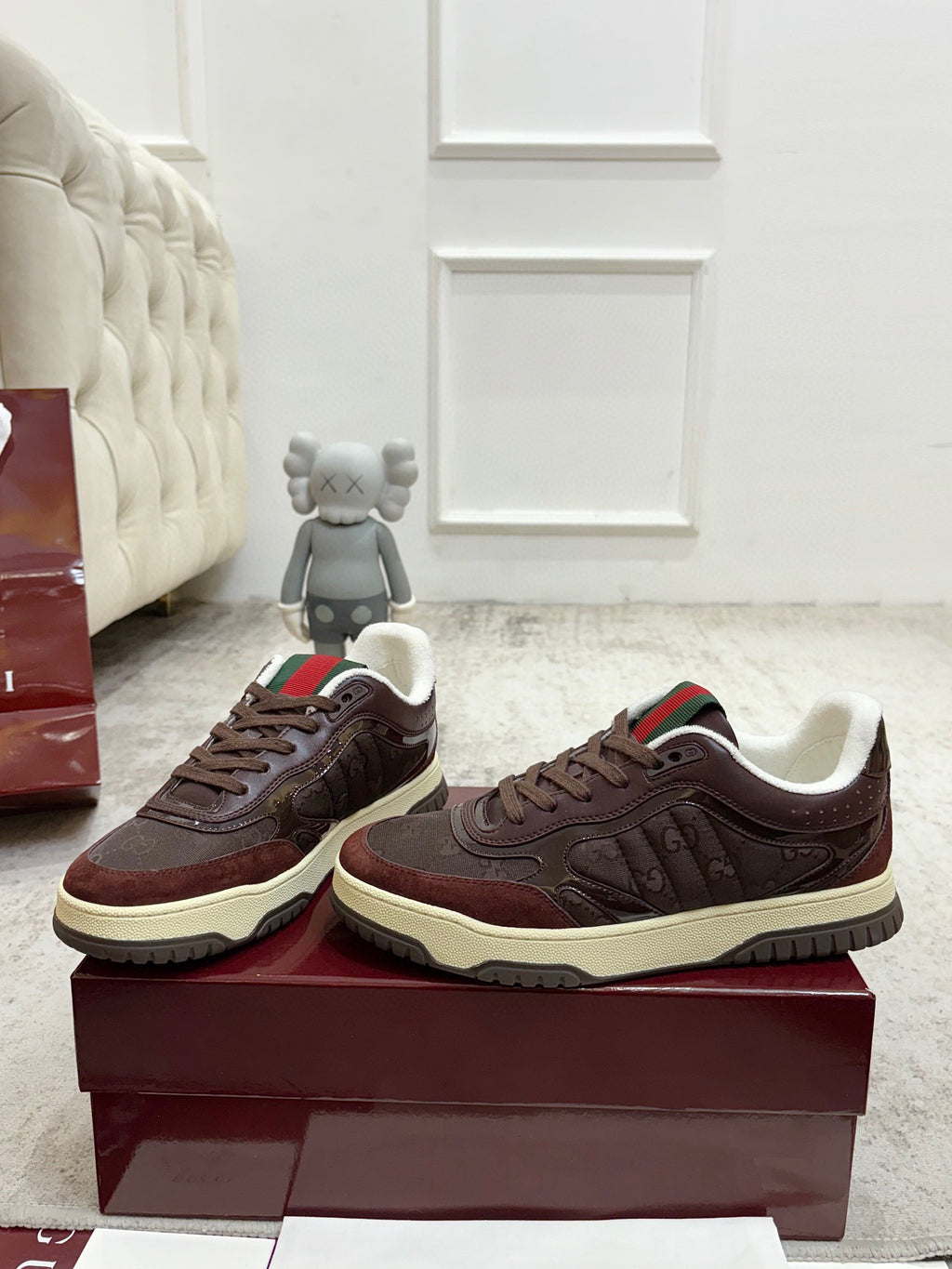 Gucci unisex sneakers side-by-side, dark brown uppers with cream soles and striped collars