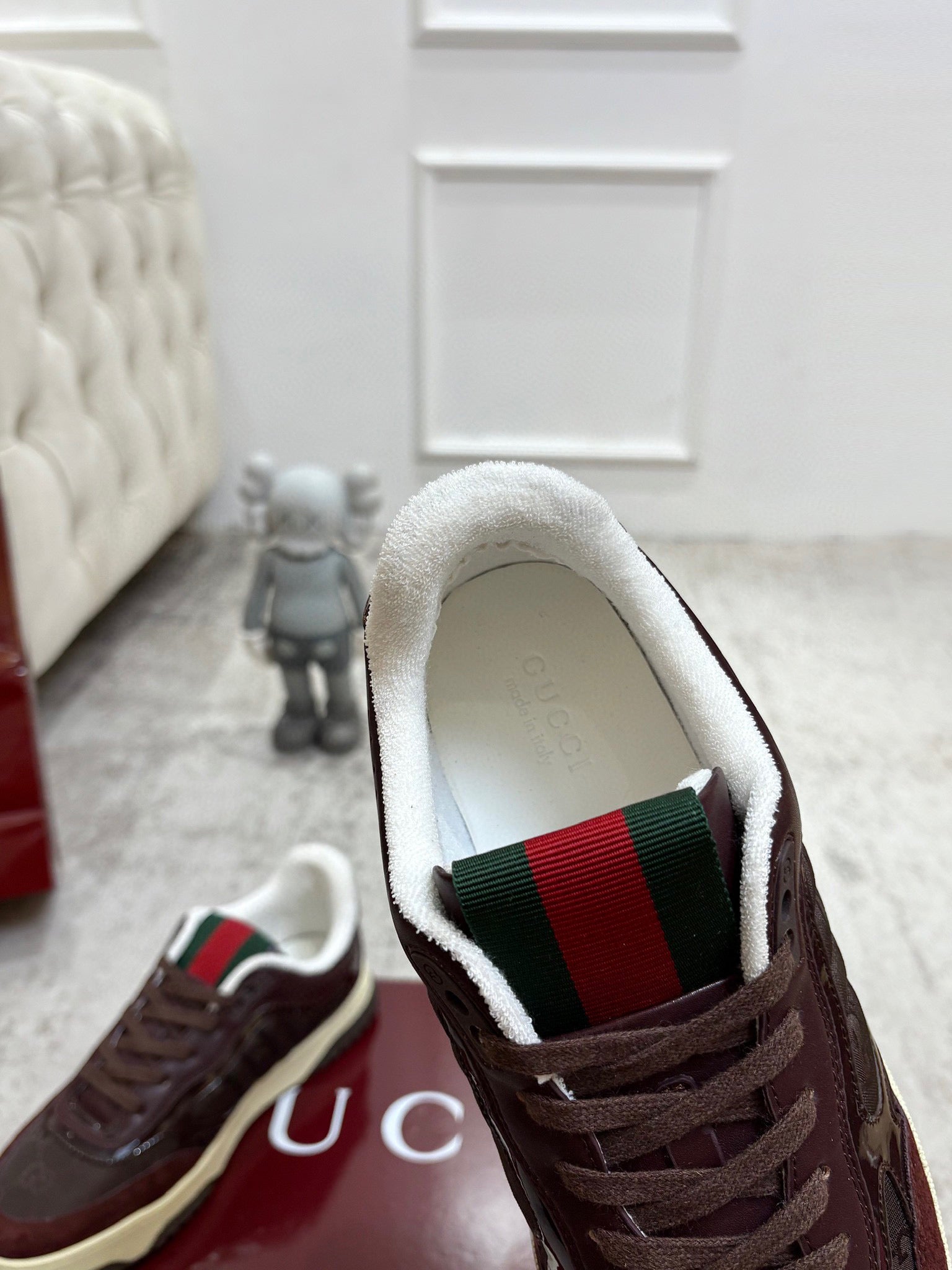 Gucci unisex sneaker interior view with dark brown laces and green red web trim lining